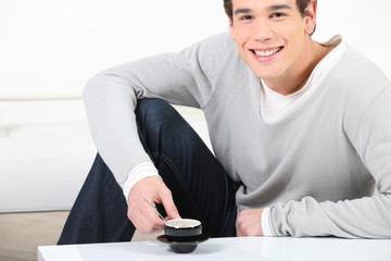 Portrait d'un jeune homme souriant avec tasse de café