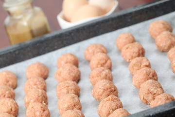 Raw meatballs on baking sheet