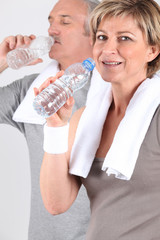 Homme et femme senior buvant de l'eau après le sport