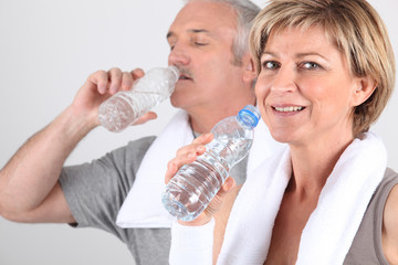 Homme et femme senior buvant de l'eau après le sport