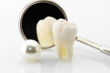 Real human wisdom tooth, natural pearl and dental mirror