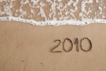 Year 2010 written on the sand