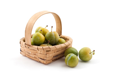Basket of plums on white background