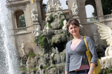 Fototapeta na wymiar Woman poses on fountain background