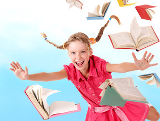 Schoolgirl  holding pile of books. Outdoor.