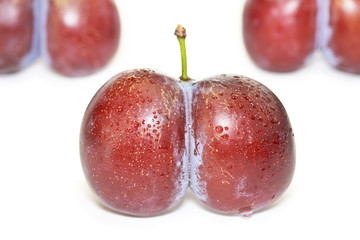 Fresh ripe twinned plums isolated on white