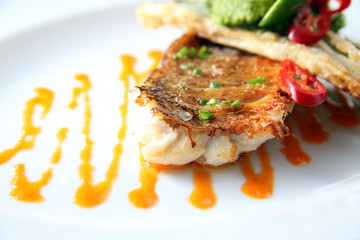 ourmet Fried Snapper on White Plate: A Food Stylist's Delight. This gourmet dish is meticulously...