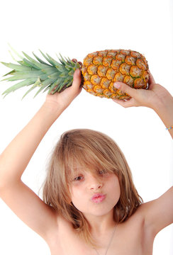 Enfant faisant la moue soulevant  Ananas