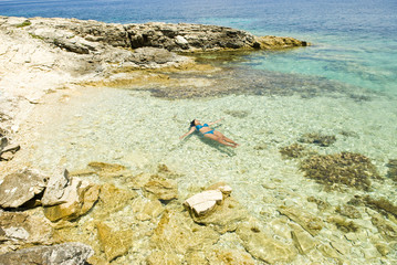 beautiful asian woman floating in the sea in Greece.