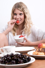 Obraz na płótnie Canvas Junge blonde Frau beim Frühstück