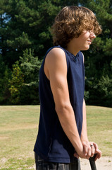 boy resting/leaning on his baseball bat