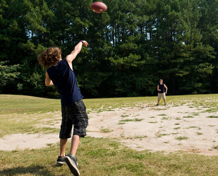 Boy Throwing Football To His Brother