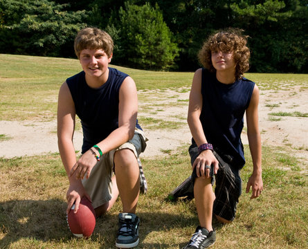Two Teen Boys Posing With Football, Kneeling
