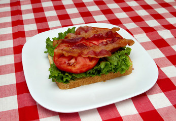 bacon, lettuce and tomato on bread - making a blt