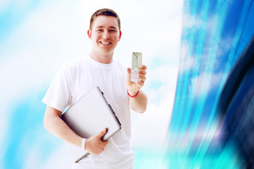 Young happy man or student with laptop and phone on the business