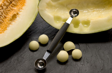 cut out honeydew melon with a scooper - obrazy, fototapety, plakaty