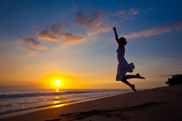 Fototapeta na wymiar Young girl jumping in the sunset