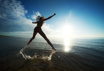 Fototapeta na wymiar Girl jumping in the sea
