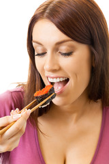 Young happy woman eating sushi roll by chopsticks, isolated