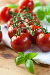 Fresh cherry tomatoes and basil on kitchen table