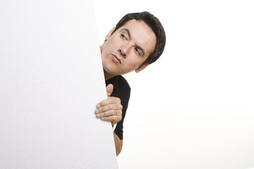 man peeking behind empty billboard