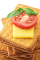 Crackers with cheese, tomato and basil