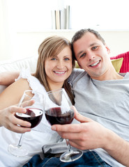 Loving young couple drinking wine sitting on a sofa