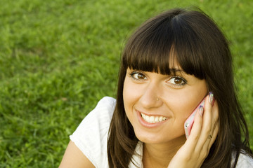 Young beautiful woman on the phone in the park.