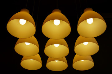 Set of ceiling lamps hanging on long cords in the darkness