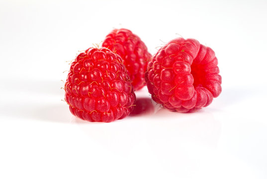 trois d&eacute;licieuses framboises en gros plan, fond blanc