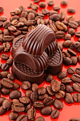 Chocolate and coffee beans on red background