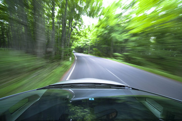 Fototapeta premium car driving fast into forest