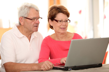 Closeup of senior couple doing online shopping