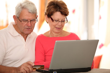 Closeup of senior couple doing online shopping