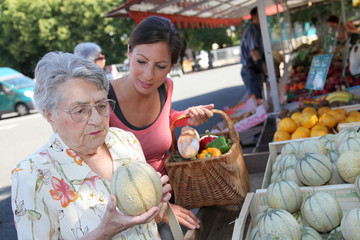 Young woman helping elderly woman with grocery shopping