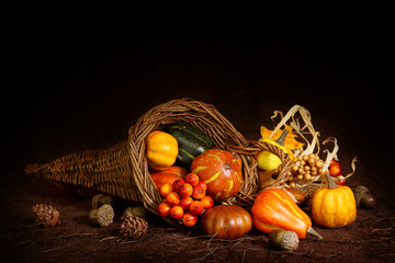 Cornucopia with pumpkins on brown background