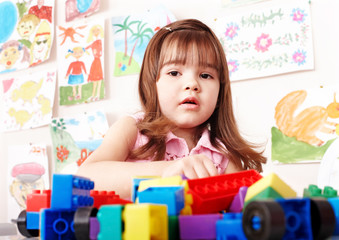 Child playing construction set in play room.