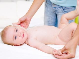 Mother massaging of newborn baby