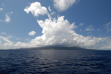 Clouds over island at ocean