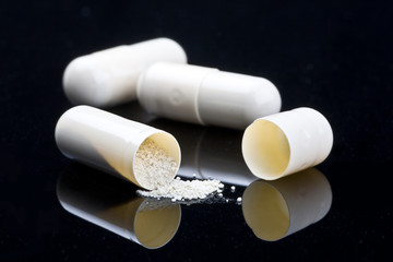 close-up of three white medical capsules isolated on black
