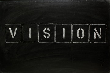 The word VISION in stencil letters on blackboard