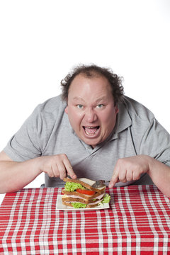 homme ob&egrave;se mangeant un sandwich avec voracit&eacute;