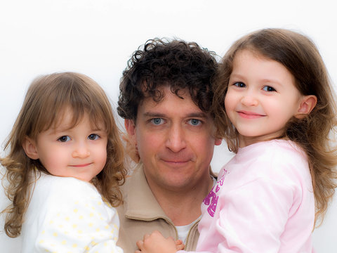 pap&agrave; che tiene in braccio due bimbe