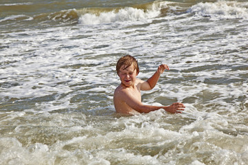 Fototapeta premium boy enjoying the waves in the wild ocean