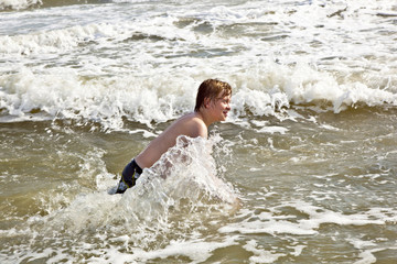 boy enjoying the waves in the wild ocean