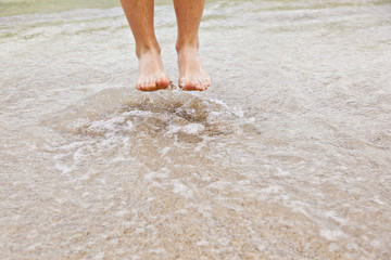 feet of boy jumping into the water