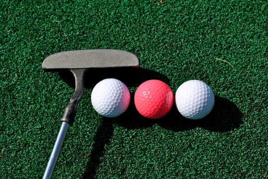 putter and three golf balls