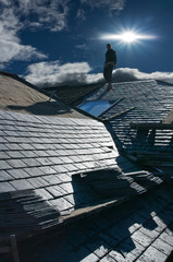 Silhouett of roofer on roof - obrazy, fototapety, plakaty