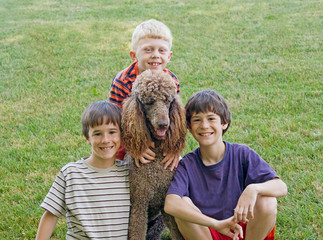 Three Boys Playing With Their Dog
