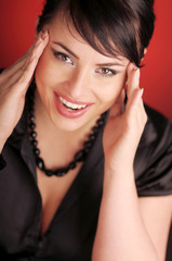 Atractive brunette woman in black shirt on red background